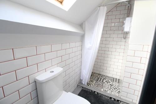 a white bathroom with a toilet and a shower at Anfield house in Liverpool