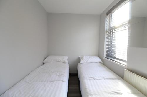 two beds in a small room with a window at Anfield house in Liverpool