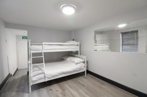 Cette chambre comprend 2 lits superposés et un miroir. dans l'établissement Anfield house, à Liverpool