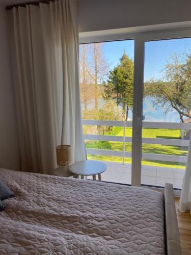 a bedroom with a bed and a large window at Dom Dwa Jeziora - Augustów in Augustów
