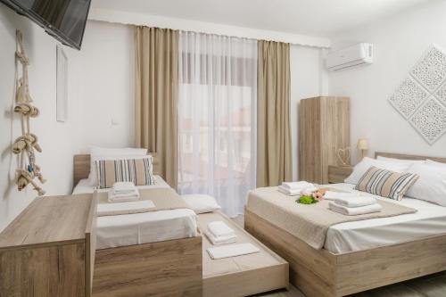 a hotel room with two beds and a window at SAND rooms to let in Nea Roda
