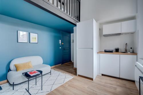 un salon avec un mur bleu, une chaise et une table dans l'établissement L'Oceà - Proche métro & stadium - Le Busca, à Toulouse