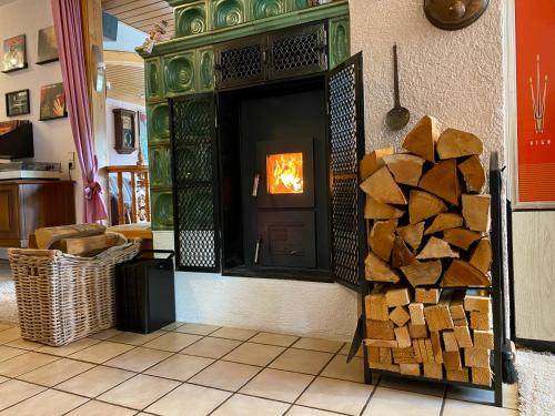 a fireplace with a pile of fire wood in a room at Ferienwohnung zur Bierliebe - Mit toller Aussicht im Herzen des Schwarzwaldes in Hornberg