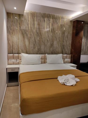 a bedroom with a bed with two towels on it at TGS Dine Inn in Port Blair