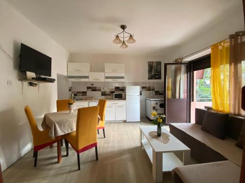 cocina y sala de estar con mesa y sillas en Apartments Vido, en Kotor