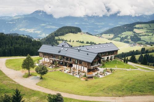 ein großes Gebäude auf einem Hügel mit Bergen im Hintergrund in der Unterkunft KRAFTalm in Itter