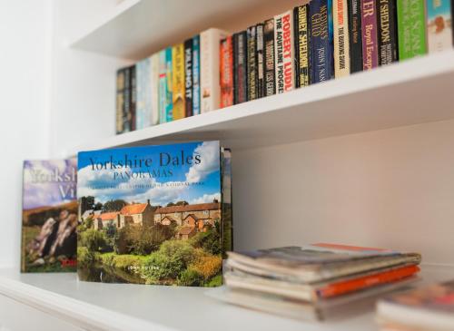 two books are sitting on a book shelf at Thisledo Holiday Cottage, Woodman Terrace, Skipton - Pet Friendly in Skipton