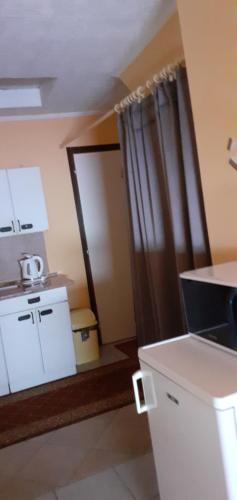 una cocina con fregadero y una puerta a una habitación en Éva vendégház en Egerszalók