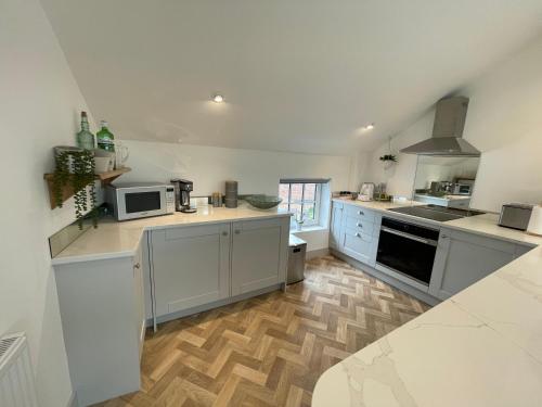 a large kitchen with white counters and appliances at Lees Lookout Holt ,2 bedroom luxury apartment with private parking in Holt