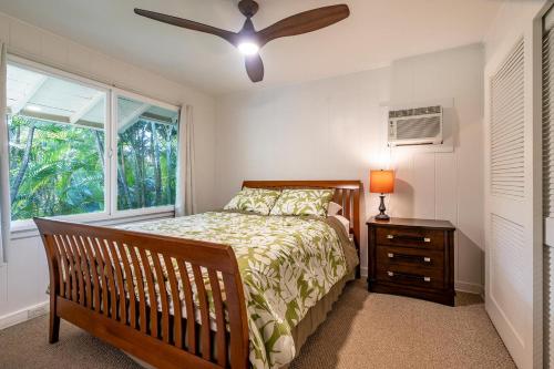 um quarto com uma cama e uma ventoinha de tecto em Waimea Bay Garden Bunglaow em Haleiwa