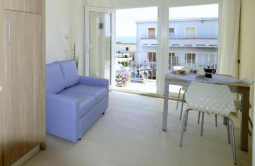 - un salon avec un canapé bleu et une table dans l'établissement VIRGOLA ZERO HOLIDAY BEACH, à Porto Potenza Picena