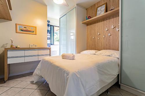 um quarto com uma cama grande e uma cabeceira em madeira em Apto com sacada e churrasq 100m Praia Brava COI302 em Florianópolis