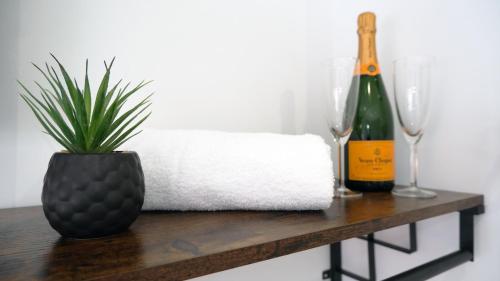 - une table avec une bouteille de champagne et une plante dans l'établissement The Kop End Hotel by Serviced Living Liverpool, à Liverpool