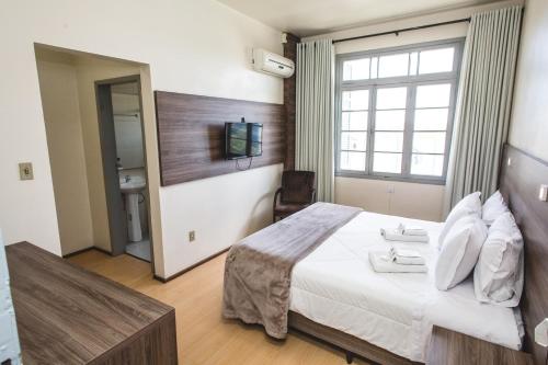 Una cama o camas en una habitación de Hotel Pousada São Lourenço