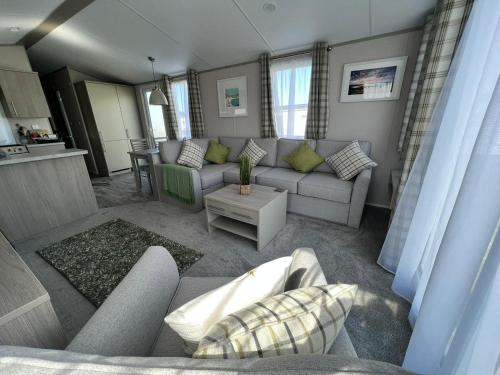 ein Wohnzimmer mit einem Sofa und einem Tisch in der Unterkunft Summer Breeze @ Seven Bays, Padstow in Padstow