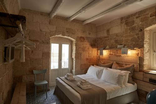 a bedroom with a large bed in a brick wall at Dei Serafini in Polignano a Mare