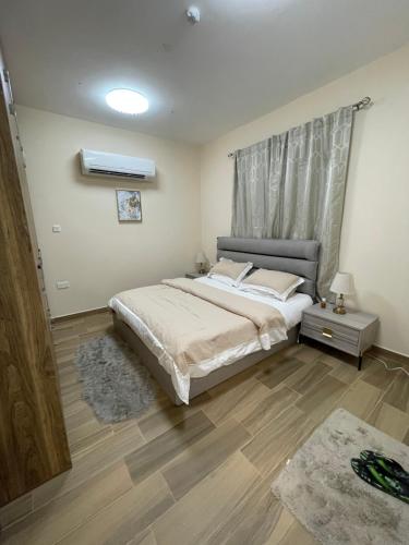 a bedroom with a large bed and a wooden floor at Yas Hotel Apartments in Al Ain