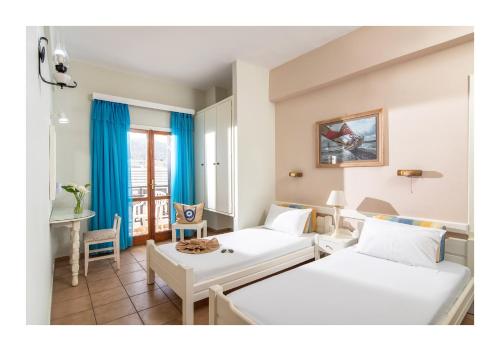 a hotel room with two beds and a table at Malia Semiramis by Estia in Malia