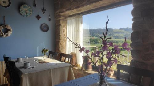 comedor con mesa y ventana grande en Casal de Folgueiras Rias Baixas, en Meis