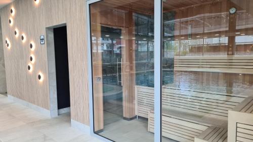 a glass facade of a building with a swimming pool at Apartament Klifowa Rewal 16 in Rewal