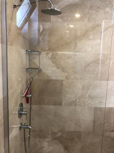 a shower with a glass door in a bathroom at Stone House Aparts 2 plus 1 mit zwei Balkone und Poolview Kalkan No 10 in Kas