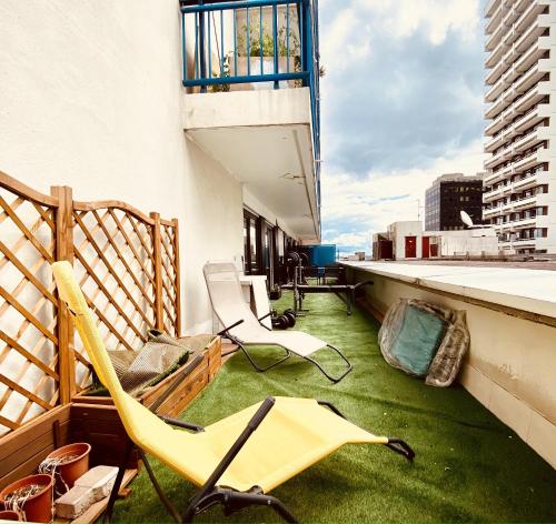 un balcone con sedie e prato verde su un edificio di Appartement centre ville avec terrasse + petit dej a Nancy