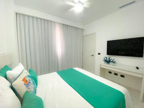 a bedroom with a bed and a flat screen tv at Xeliter Cana Rock Punta Cana in Punta Cana