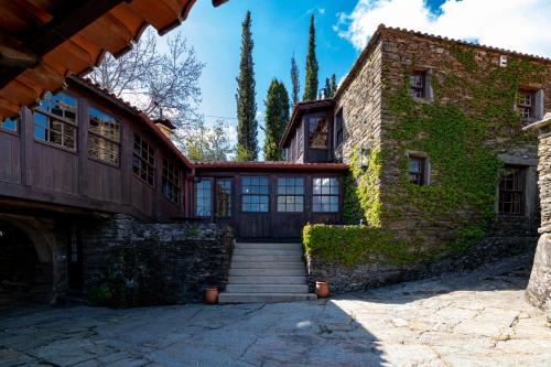una antigua casa de piedra con una escalera que conduce a ella en Quinta de Mourães - Casa do Xisto en Lever