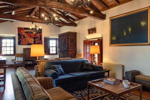a living room with a blue couch and a table at Quinta de Mourães - Casa do Xisto in Lever