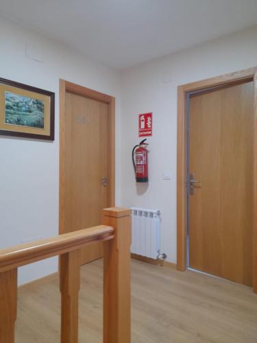 a room with a door and a fire extinguisher on the wall at SLEEPING PORTOMARIN 2 in Portomarin