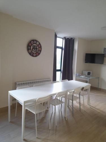 a white table and chairs in a room at SLEEPING PORTOMARIN 2 in Portomarin