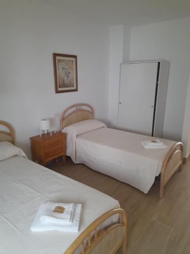 Habitación con 2 camas y mesa con espejo. en SLEEPING PORTOMARIN 2, en Portomarín