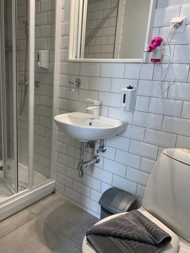 a bathroom with a sink and a shower and a toilet at NB Hotel with Free Parking in Rīga