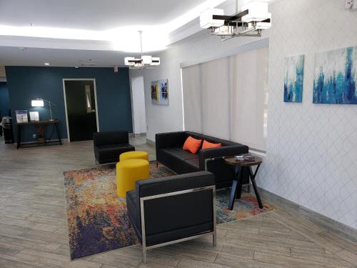 a living room with a black couch and a yellow stool at Quality Inn & Suites Clemmons I-40 in Clemmons