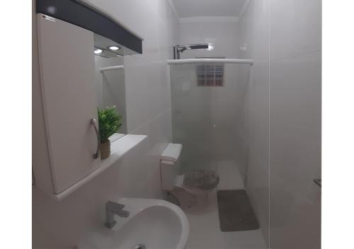 Baño blanco con aseo y lavamanos en Casa incrível com 2 quartos e estacionamento incluso, en Maringá