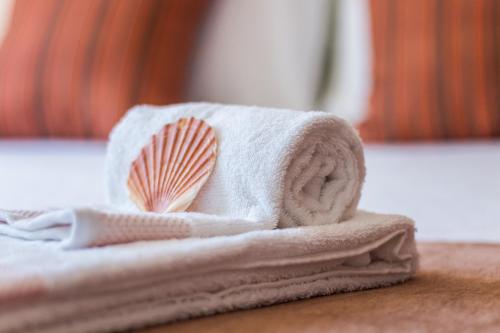 a white towel with a shell on top of it at Casa Mar Praia dos Pescadores By ALzira in Albufeira