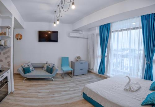 1 dormitorio con cortinas azules, 1 cama y 1 silla en Duo Apartament, en Năvodari