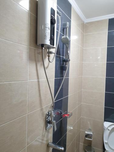 a shower in a bathroom next to a toilet at Lovely 2 and 1 bedroom guest units Karen in Nairobi