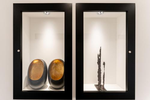 two glass display cases with a vase and a plant at Nero Luxury Suites in Cagliari