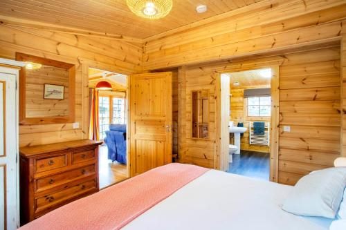 a bedroom with a bed in a wooden cabin at Willowbank Lodges in Oare