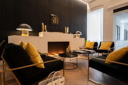 a living room with black and yellow furniture and a fireplace at Nero Luxury Suites in Cagliari