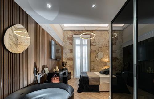 a bathroom with a bed and a tub in a room at Nero Luxury Suites in Cagliari