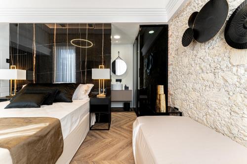 a bedroom with two beds and a wall at Nero Luxury Suites in Cagliari