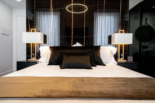 a bedroom with a large bed with two lamps at Nero Luxury Suites in Cagliari