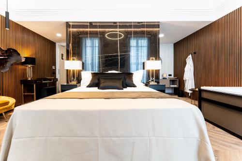 a bedroom with a large white bed and a desk at Nero Luxury Suites in Cagliari