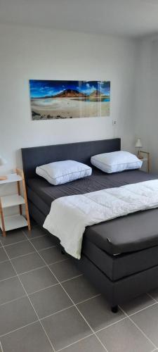 a bedroom with two beds and a painting on the wall at Bungalow Plattedijk 25-34 in Lemmer