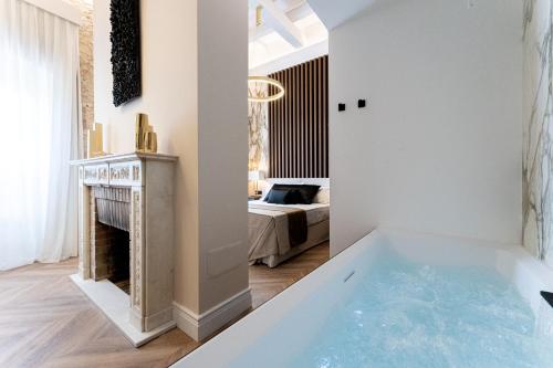 a bath tub in a room with a bedroom at Nero Luxury Suites in Cagliari
