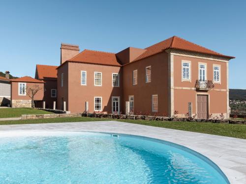 uma casa grande com uma piscina em frente em Casa Noronha Lima - Historic Stay em Alvarenga