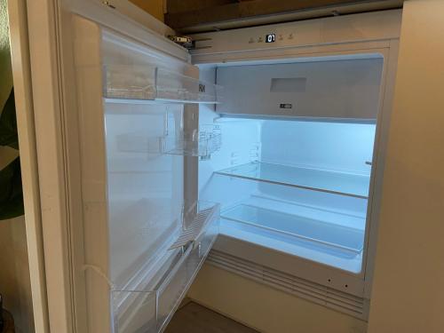 an empty refrigerator with its door open in a kitchen at Bed en Koffie Casa Mañana de Koog in De Koog