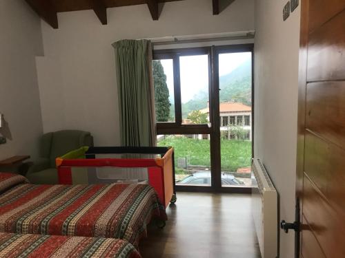 a bedroom with a bed and a sliding glass door at Casa Peñavera-Somiedo in Caunedo